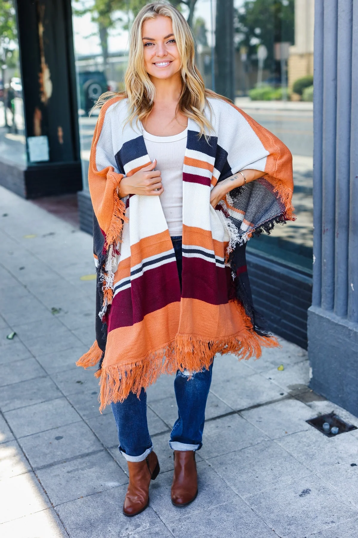 Zoe | Follow Me Rust colored open poncho with multi colored stripes and tassel fringes
